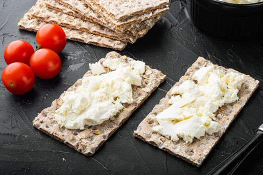 Fresh rye crispbreads with different topping set, on black dark stone table background