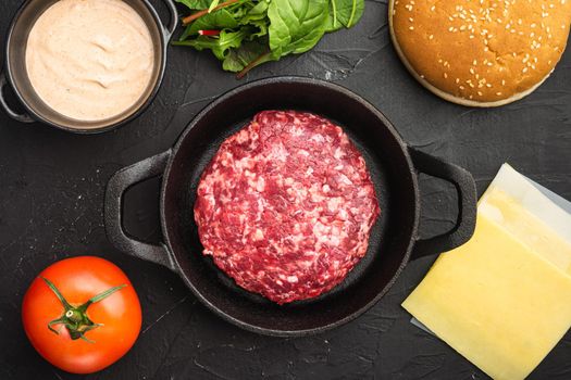 Raw Ground beef meat Burger steak cutlets set, on black stone background, top view flat lay