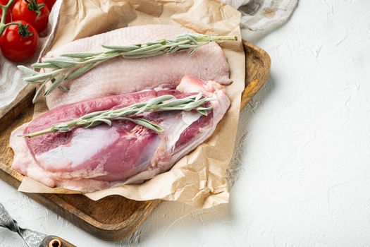 Fresh duck meat for food, Raw duck breast set, with herbs and ingredients, on wooden tray, on white stone background, with copyspace and space for text