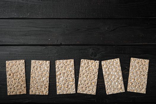 Buckwheat crisp bread set, on black wooden table background, top view flat lay, with copy space for text