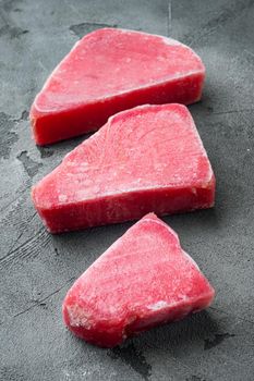 Raw frozen tuna fish fillet set, on gray stone background