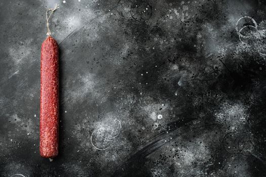 Salami sausage set, on black dark stone background, top view flat lay, with copy space for text