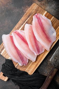Tilapia fish, skinless meat, on old rustic background, top view