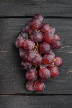 Natural organic juicy grapes set, dark red fruits, on black wooden table, top view flat lay