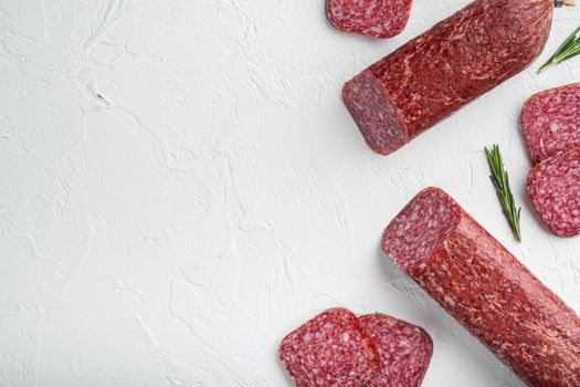 Salami with fresh rosemary and spices set, on white stone table background, top view flat lay, with copy space for text