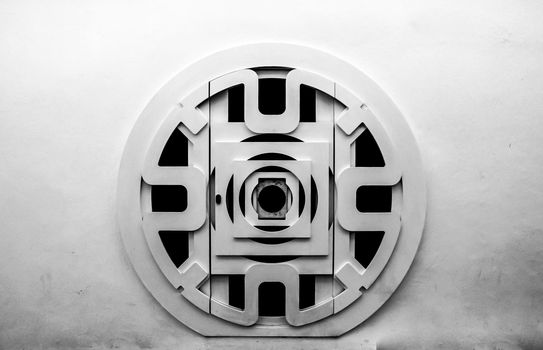 Circular wooden door with black iron details  and whitewashed facade in Altea, Alicante, Spain.
