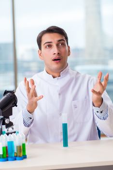 Young chemist student working in lab on chemicals