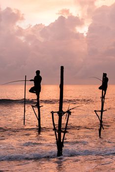 Silhouettes of the traditional Sri Lankan stilt fishermen on a stormy in Koggala, Sri Lanka. Stilt fishing is a method of fishing unique to the island country of Sri Lanka