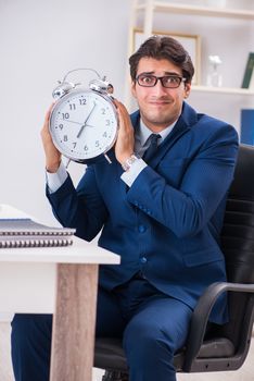 Businessman employee in urgency and deadline concept with alarm clock