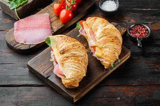 Fresh croissant or sandwich with salad, ham, jamon, prosciutto set, with herbs and ingredients, on old dark wooden table background