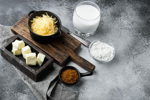 Preparation of bechamel cheese white sauce set, on gray stone background, with copy space for text