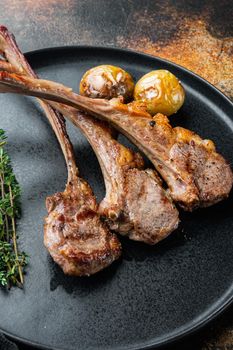 Grilled Lamb Steak with orange, garlic and carrot set, on plate, on old dark rustic background