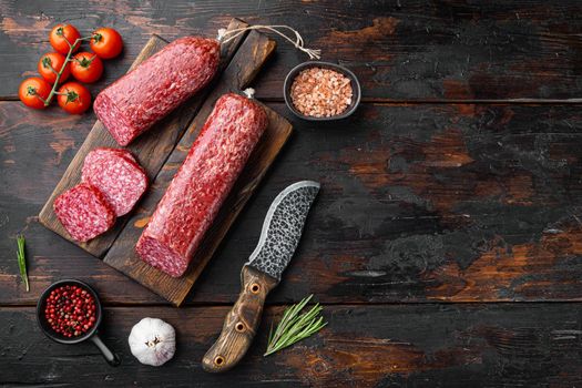 Salami with herbs , garlic set, on old dark wooden table background, top view flat lay, with copy space for text