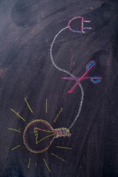 Graphic representation of the concept of electricity savings, drawn with chalk on blackboard