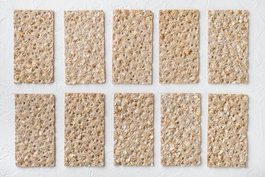 Crispbread with sunflower, chia and sesames seeds set, on white stone table background, top view flat lay, with copy space for text