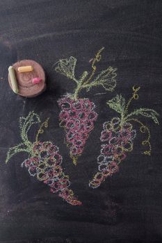 Representation with chalk on blackboard three bunches of red grapes