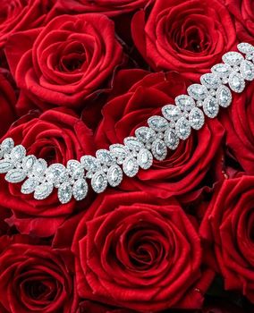 Gemstone jewellery, wedding fashion and luxe shopping concept - Luxury diamond bracelet and bouquet of red roses, jewelry love gift on Valentines Day and romantic holidays present