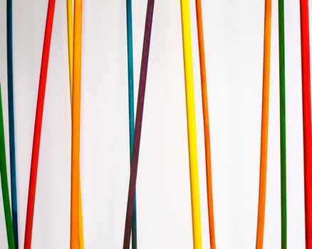 Colored dowels hang against a white background.