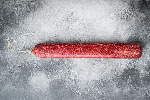 Whole sausage salami set, on gray stone table background, top view flat lay, with copy space for text