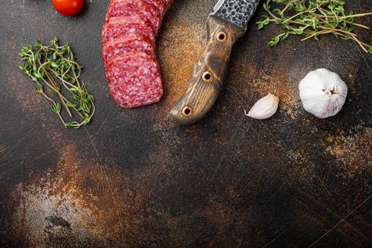 Salami with herbs , garlic set, on old dark rustic table background, top view flat lay, with copy space for text