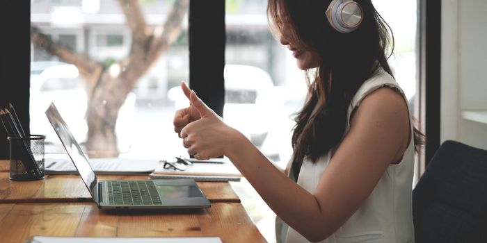 Young woman gammer or blogger influencer sit looking at camera make video conference call recording vlog in living room at her home