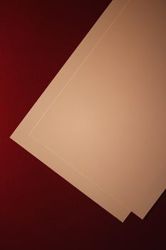 Blank A4 paper, beige on dark red background as office stationery flatlay, luxury branding flat lay and brand identity design for mockups