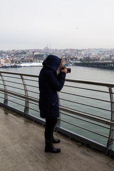 tourist girl photographer with dslr camera outdoor on the bridge in Golden Horn
