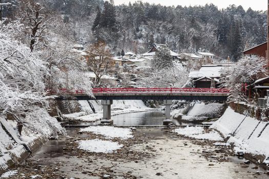 Nakabashi Bridge with snow fall and Miyakawa river in winter season . Landmark of Hida - Gifu - Takayama , Japan . Landscape view .