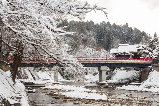 Nakabashi Bridge with snow fall and Miyakawa river in winter season . Landmark of Hida , Gifu , Takayama , Japan . Landscape view .