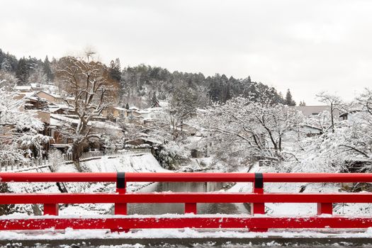 Nakabashi Bridge with snow fall and Miyakawa river in winter season . Landmark of Hida , Gifu , Takayama , Japan . Landscape view .
