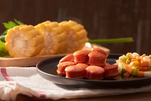 Sliced and fried sausage with salad seen from above close