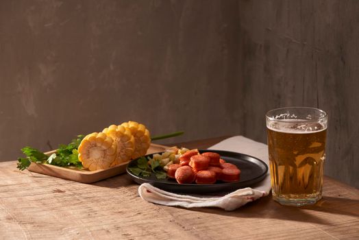 Beer and appetizing beer snacks set. Table with mug beer grilled sausages with sauces.