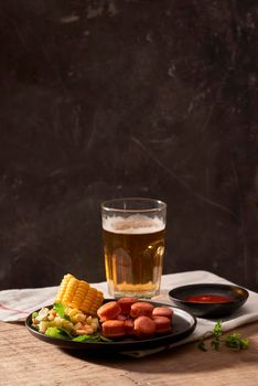 Beer and appetizing beer snacks set. Table with mug beer grilled sausages with sauces.