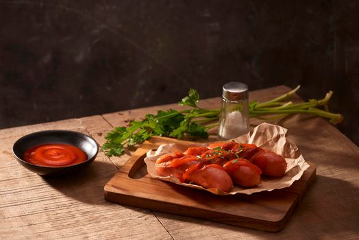 Grilled sausages with sauce ketchup on a wooden table