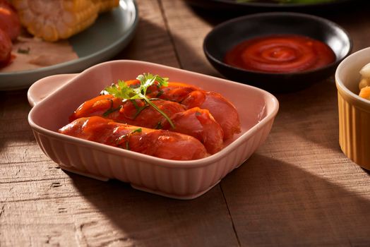 Grilled sausages with sauce ketchup on a wooden table