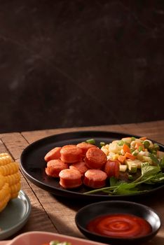 Grilled sausages with sauce ketchup on a wooden table