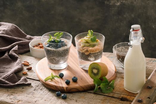 Healthy breakfast - bowl of muesli, berries and fruit, nuts, kiwi, milk