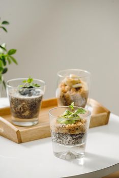 Fruits yogurt parfait with granola and chia seeds for healthy breakfast on wooden table