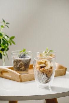 Fruits yogurt parfait with granola and chia seeds for healthy breakfast on wooden table