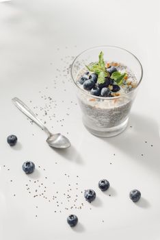 Healthy breakfast or morning snack with chia seeds vanilla pudding and berries on wooden background, vegetarian food, diet and health concept