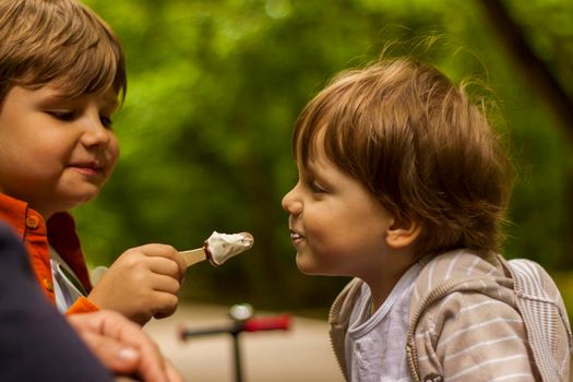 Children have fun in the park. Walk, play and eat ice cream. Emotions, joy. 