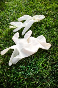 Photographic representation of a pair of disposable anti Coronavirus gloves thrown into the ground causing pollution. 