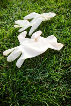 Photographic representation of a pair of disposable anti Coronavirus gloves thrown into the ground causing pollution. 