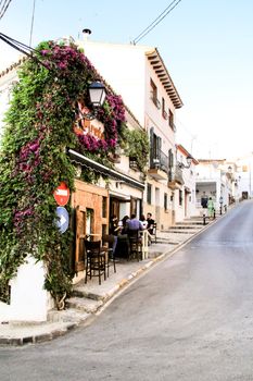 Altea, Alicante, Spain- June 12, 2021: People having drinks and enjoying nice weather in terraces in the streets of Altea village in Spain. 