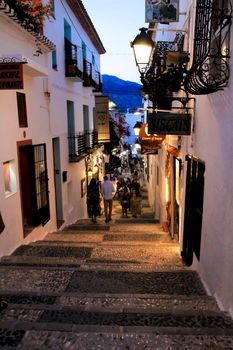 Altea, Alicante, Spain- June 12, 2021: People going shopping, walking and relaxing at night through the Narrow streets of Altea village, Alicante, Spain