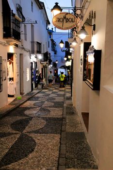 Altea, Alicante, Spain- June 12, 2021: People going shopping, walking and relaxing at night through the Narrow streets of Altea village, Alicante, Spain
