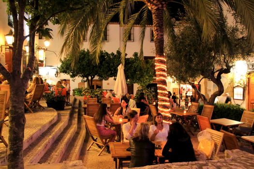 Altea, Alicante, Spain- June 12, 2021: People having drinks and enjoying nice weather in terraces at night in Altea village in Spain. 