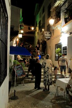 Altea, Alicante, Spain- June 12, 2021: People going shopping, walking and relaxing at night through the Narrow streets of Altea village, Alicante, Spain