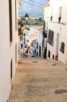 Altea, Alicante, Spain- June 12, 2021: Narrow streets and typical whitewashed facades in Altea village, Alicante, Spain