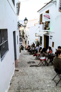 Altea, Alicante, Spain- June 12, 2021: People having drinks and enjoying nice weather in terraces in the streets of Altea village in Spain. 